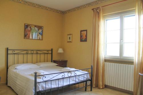 a bedroom with a bed and a window at Boteroom Relais in La Volla
