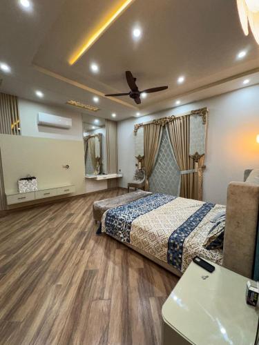 Un dormitorio con dos camas y un ventilador de techo. en Shaheen Palace, en Faisalabad