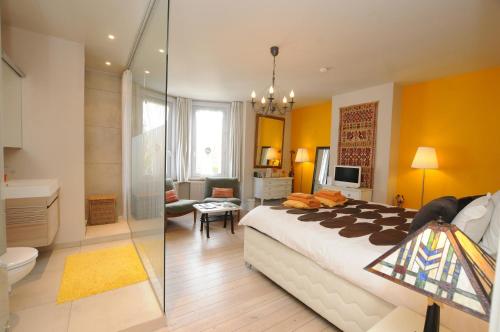 a bedroom with a large bed and a bathroom at R&breakfast in Roeselare