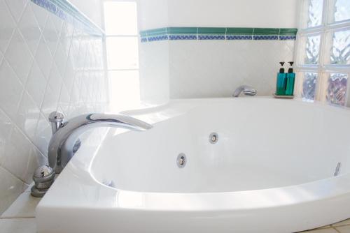a bathroom with a white tub and a sink at Boteroom Relais in La Volla