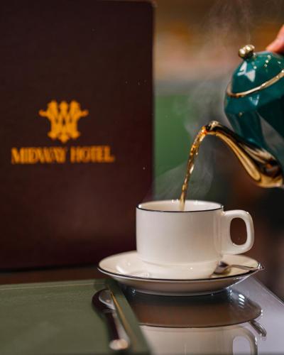 a teapot pouring tea into a cup on a table at Midway Hotel Baku in Baku