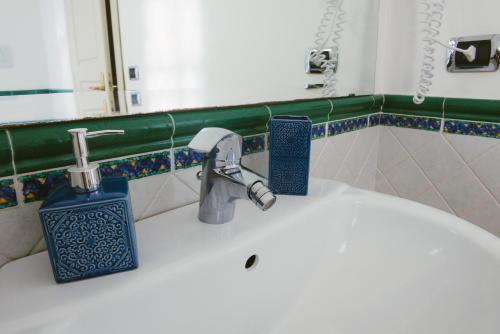 a bathroom sink with a faucet and a mirror at Boteroom Relais in La Volla