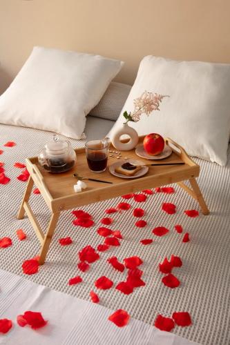a table on a bed with red hearts on the floor at Atlantic view studio with Kitchen by Casa in Ebomé