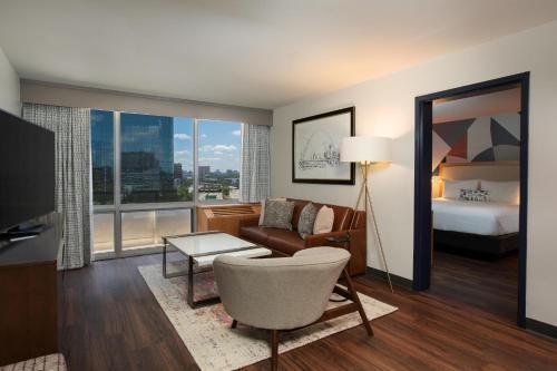 a living room with a bed and a living room with a couch at The Beeman Hotel in Dallas