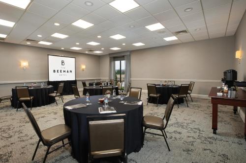 a conference room with tables and chairs and a screen at The Beeman Hotel in Dallas