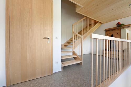 a staircase in a house with a wooden door at Ferienhof Landerleben in Egg
