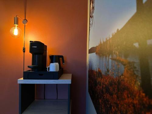 a coffee maker sitting on a table next to a painting at Radisson Blu Resort, Beitostølen in Beitostøl