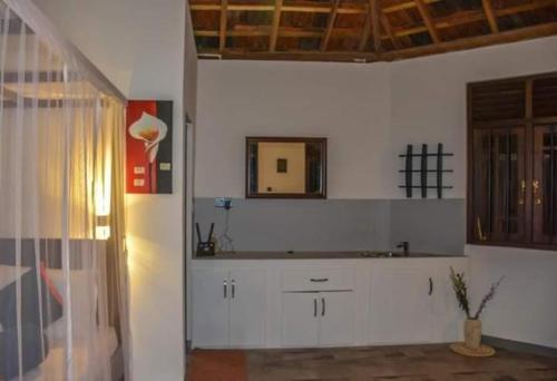 a kitchen with white cabinets and a mirror on the wall at Heaven View Tangalle in Tangalle