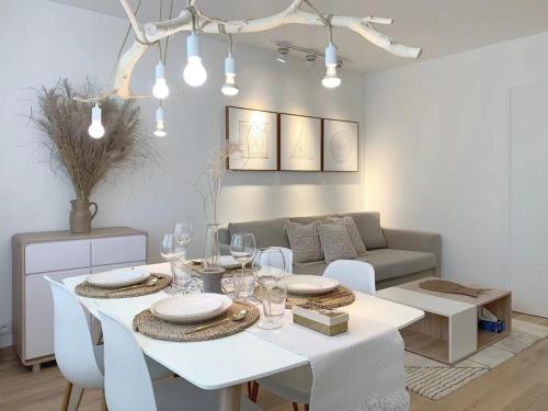 une salle à manger blanche avec une table et des chaises blanches dans l'établissement apt lumieuse confor parking free, à Paris