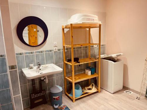La salle de bains est pourvue d'un lavabo et d'une étagère à côté d'un réfrigérateur. dans l'établissement La grange de Pierrot proche de Salers, 10pers, 4ch, à Girgols