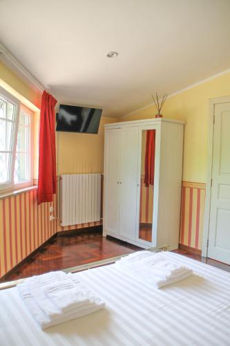 a bedroom with a white bed and a cabinet at Boteroom Relais in La Volla