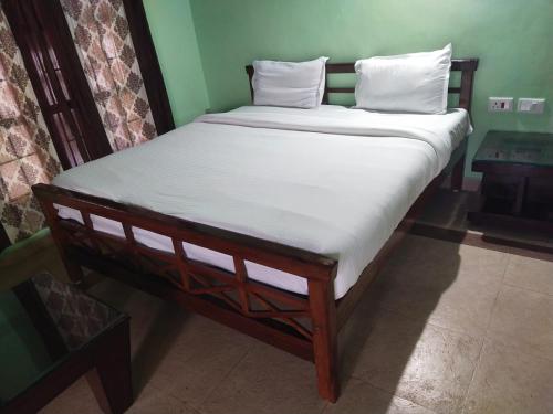 a bed with white sheets and pillows in a room at Deep view luxury villa Coffee Cottage Coorg in Madikeri