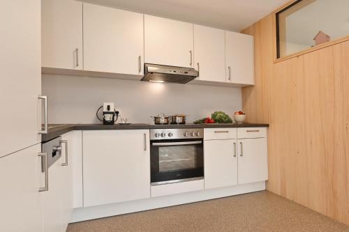 a kitchen with white cabinets and a stove at Ferienhof Landerleben in Egg