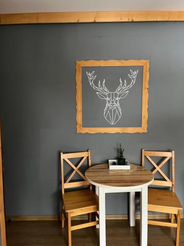a dining room with a table and two chairs at WIlla JODŁA JACUZZI&SAUNA in Poronin