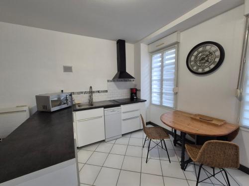 une cuisine avec une table et une horloge au mur dans l'établissement Urban Chic 44 m2, à Brest