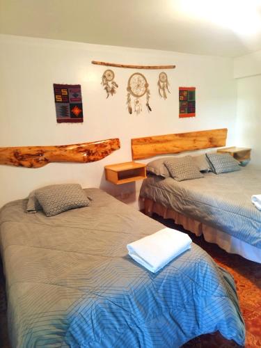 a bedroom with two beds and a clock on the wall at casa hostel vacahouse Huaraz in Huaraz