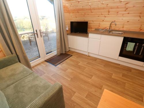 a kitchen and living room with a couch and a television at Audrey in Penzance
