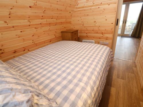a bedroom with a bed in a wooden room at Audrey in Penzance