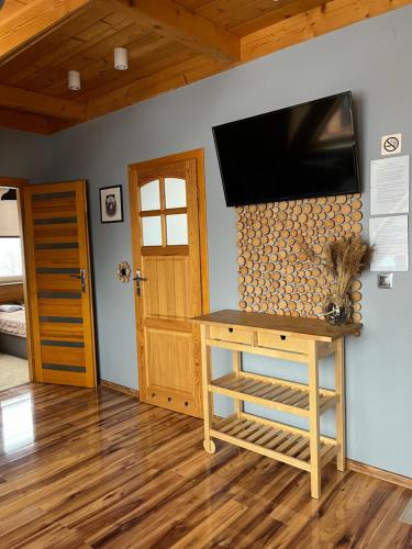 a room with a table and a television on a wall at WIlla JODŁA JACUZZI&SAUNA in Poronin