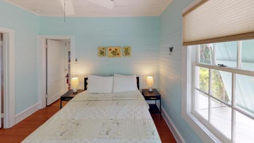 a bedroom with a bed with two lamps and a window at Jasmine Place in Key West