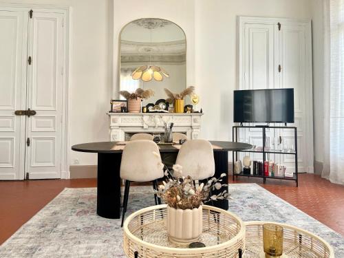 un salon avec une table et deux chaises dans l'établissement L'échappée sètoise - Appartement Haussmannien - localisation exceptionnelle - proche canal, à Sète