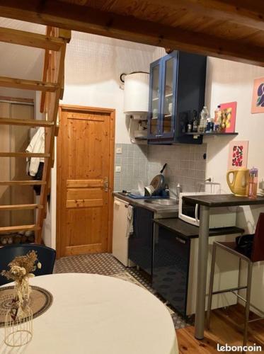 une cuisine avec un évier et une cuisinière four supérieur dans l'établissement Le Duplex de Léa, à Valenciennes