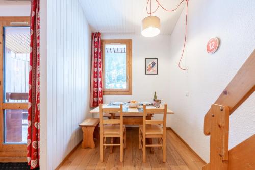 une salle à manger avec une table et des chaises en bois dans l'établissement Lauziere dessus 50, à Valmorel