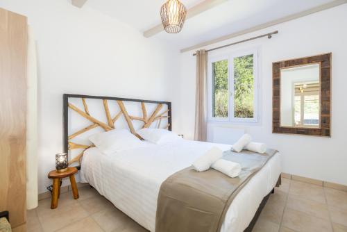 une chambre avec un grand lit blanc et une fenêtre dans l'établissement Domaine De Meyrol - Gite 1, à Eyguières