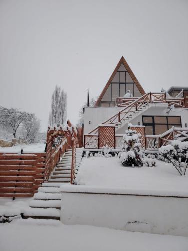 a house covered in snow with stairs in front at 40 steps Aframe House in Uçgün