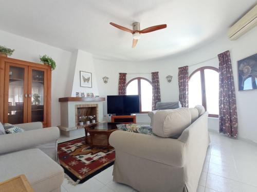 un salon avec deux canapés et une télévision dans l'établissement Villa Maravista - Luxury Villa with Private Pool and Sea View, à Benitachell