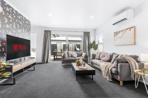 a living room with two couches and a tv at Central 2brm Retreat, Modern, Close to Shopping - By KOSH BNB in Hamilton