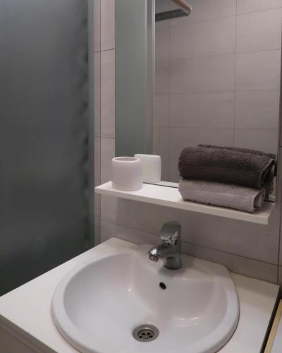 Un baño con lavabo, espejo y toallas. en The Modern Flat, en Pristina