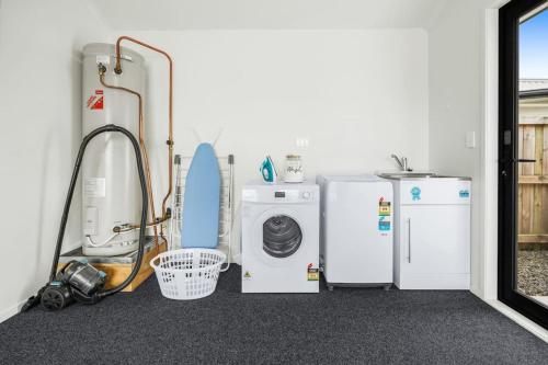a laundry room with refrigerators and a washing machine at Two Ensuites, Central Hamilton - By KOSH BNB in Hamilton