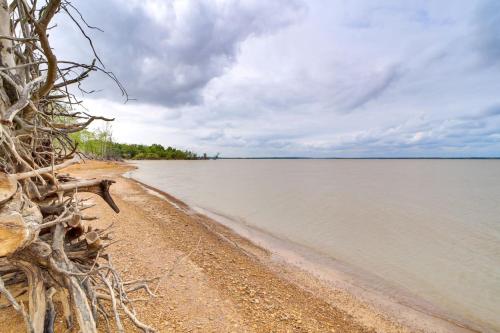 a beach with a bench next to the water at Grandview Spacious and Updated Beds for 10 in Eufaula