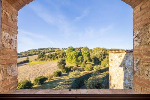 an open window with a view of a field and trees at Casale la Peschiera by VacaVilla in Monteguidi