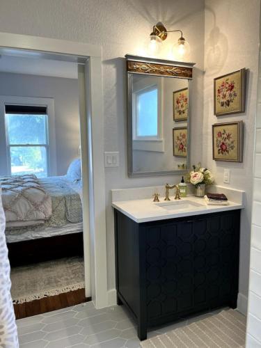 a bathroom with a sink and a mirror and a bed at Charming 2-bedroom Cottage in San Antonio
