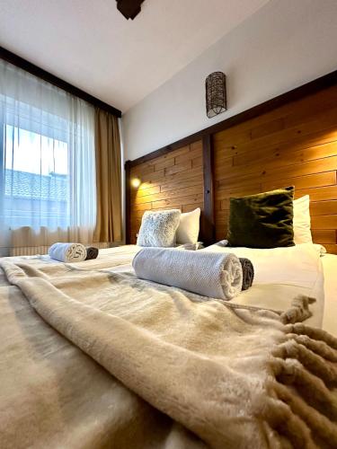 a large bed with two pillows on top of it at Red House Family house in Bansko