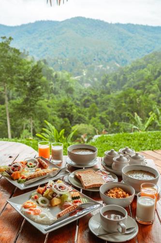 a table topped with plates of food on top of a table at Mountain Floating Cloud in Ban Kai Noi