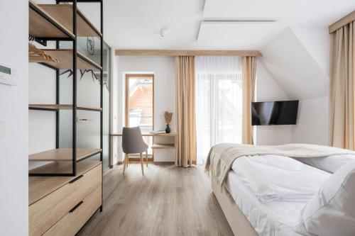 a bedroom with a bed and a desk at Apartamenty Krokusowa Dolina in Kościelisko