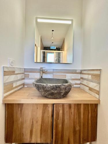 une salle de bain avec un lavabo en pierre et un miroir dans l'établissement Maison 20 du Lac Les Restanques, à Grimaud