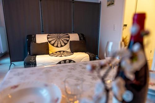 - un salon avec un canapé et une table avec des verres à vin dans l'établissement Cocon de la Baie, terrasse et parking privé, à Saint-Valery-sur-Somme