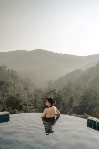 a woman is standing in a pool of water at Mountain Floating Cloud in Ban Kai Noi