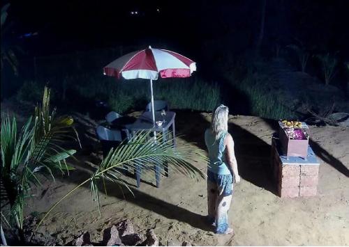a man standing in the sand under an umbrella at Casa Hillary Guest House in Colva