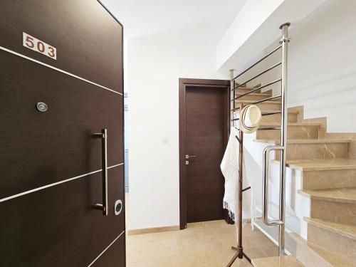 a staircase in a house with a door and a stairwell at Dios Ponte Finikoudes Beachfront in Larnaka