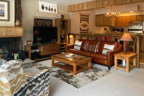 a living room with a couch and a tv at Glacier in Jackson