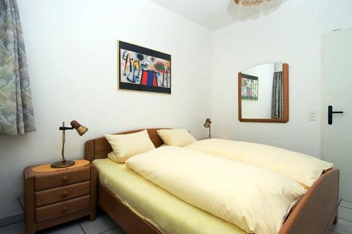 a bedroom with a bed and a lamp on a night stand at Ferienwohnung C07 in Orselina