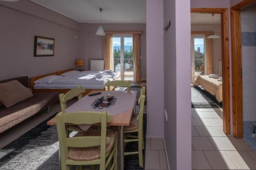a room with a table and chairs and a bed at Xenonas Drimos in Karpenision