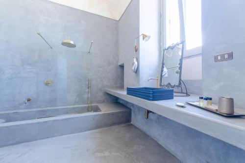 a bathroom with a tub and a sink and a mirror at Palazzo Angelica - Luxury Retreat Otranto in Giurdignano