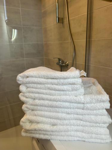 une pile de serviettes posée sur un comptoir dans une douche dans l'établissement Escapade Thermale, à Lons-le-Saunier