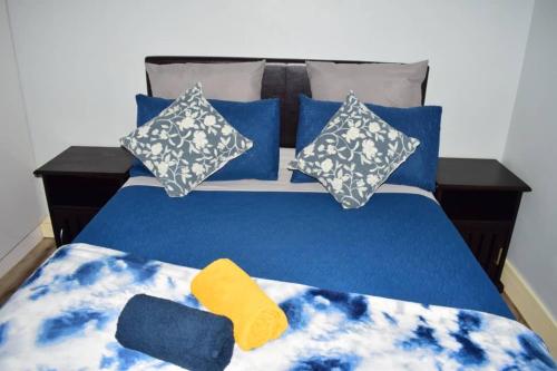 a blue bed with blue and white sheets and pillows at City Centre Self-Catering Suites in Windhoek